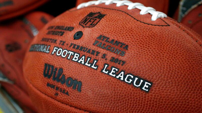 The first NFL Super Bowl LI football sits in a bin with other balls to be stamped with the New...